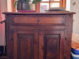 a wooden cabinet with a potted plant on top of it