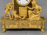 a gold clock that is sitting on top of a table