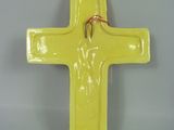 a yellow cross on a white plate with a red string