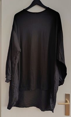 shirt hanging on a hanger on a white wall in a room