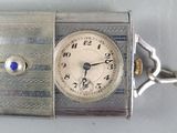 a silver clock with a chain around it on a table