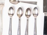 many different types of silverware on a white surface