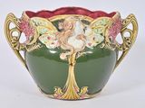 un vase vert sur lequel est représentée une femme