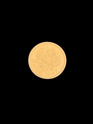 a close up of a gold coin on a black background