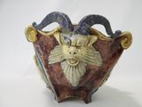 a vase with a ram head on it on a table