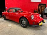 a red car parked in a garage with a red wall in the background