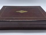 an old wooden box with a gold decoration on the lid