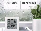 a white clock sitting on a window sill next to a potted plant