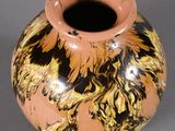 a small vase with a yellow and black design on it