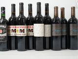 plusieurs bouteilles de vin sont alignées sur une surface blanche