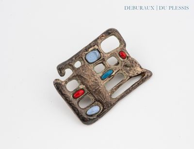 une vieille boucle en argent ornée de pierres rouges, bleues et vertes