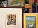 trois photos encadrées représentant des arbres et un tableau posé sur une table