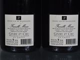 two bottles of wine sitting on top of a table next to each other