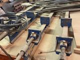 Plusieurs morceaux de bois sont posés sur un établi dans un atelier de menuiserie