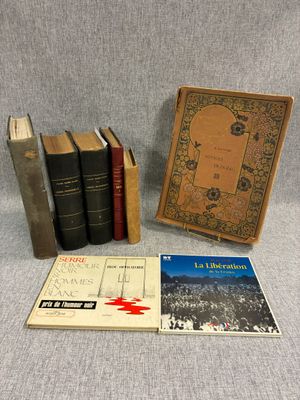 Trois livres sont posés sur une table à côté d'une bibliothèque.
