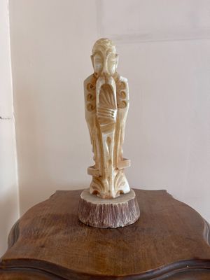 une statue représentant un homme et une femme posée sur une table en bois