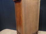 an image of a small wooden cabinet on a carpeted floor