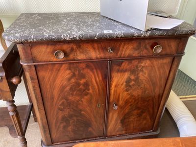 un ordinateur portable posé sur une armoire, à côté d'une chaise