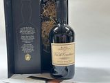 la bouteille de vin se trouve à côté d'une boîte sur laquelle est collée une étiquette