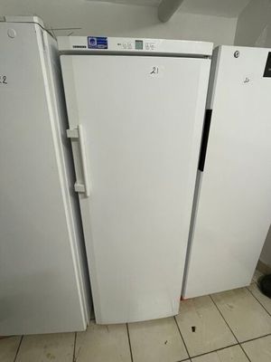 three white refrigerators in a room with tile flooring