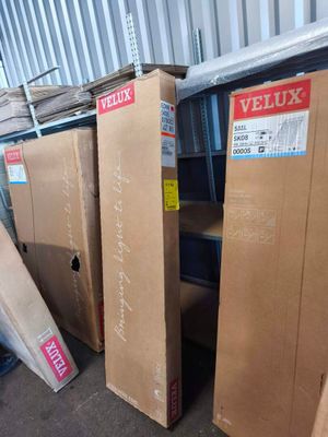 Plusieurs cartons sont empilés les uns sur les autres dans un entrepôt