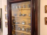 a china cabinet with a glass door in the middle of the room