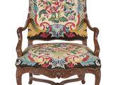 une vieille chaise avec un coussin rembourré aux couleurs vives et une structure en bois