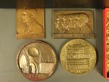 three gold and silver medals and a red box on a table