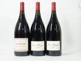 trois bouteilles de vin sont alignées sur une surface blanche