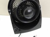 a black fan sitting on top of a table next to a charger