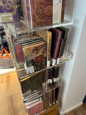 une étagère transparente sur laquelle sont posés de nombreux livres