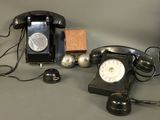 a black telephone sitting on a table next to a wooden block