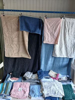 many towels hanging on a clothes rack in a room