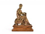 an image of a bronze statue of a woman sitting on a stool