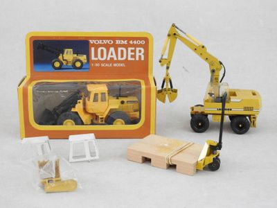a toy truck with a loader in front of a box