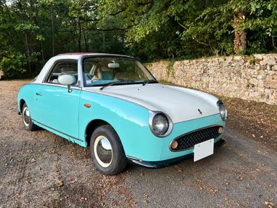 une petite voiture bleue garée sur le bord de la route