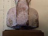 a stone statue of a man sitting on top of a table