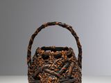 woven basket with handles on a table against a gray background