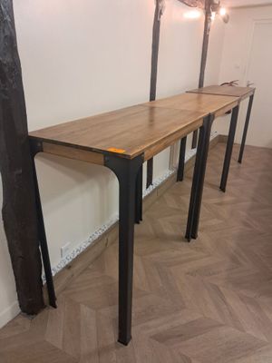 une longue table en bois avec des pieds en métal dans une pièce