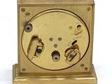 une horloge en or posée sur une surface blanche