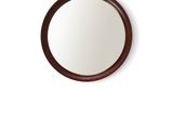 a round mirror on the wall with a wooden frame