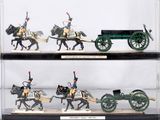 four miniature figurines of soldiers riding on horses and carts