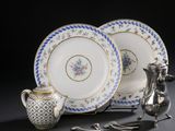 deux assiettes et une théière en argent posées sur une table