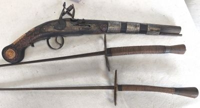 Trois types d'armes différents sont exposés sur une surface blanche