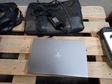 a laptop on a pallet next to a bag and a cell phone