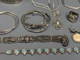 a lot of silver and turquoise jewelry on a table