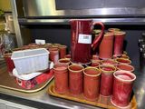 many cups and a pitcher on a tray on the kitchen counter