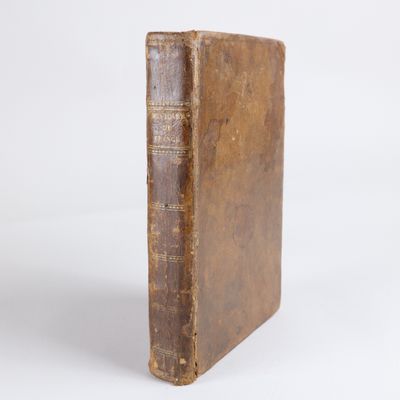 un vieux livre posé sur une surface blanche