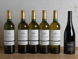 six bouteilles de vin sont alignées sur une table en bois
