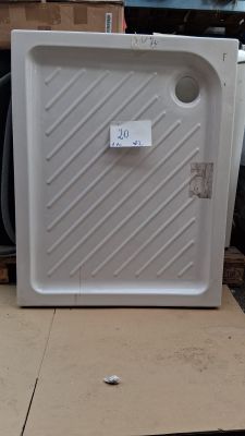un réfrigérateur blanc posé sur une palette dans un entrepôt